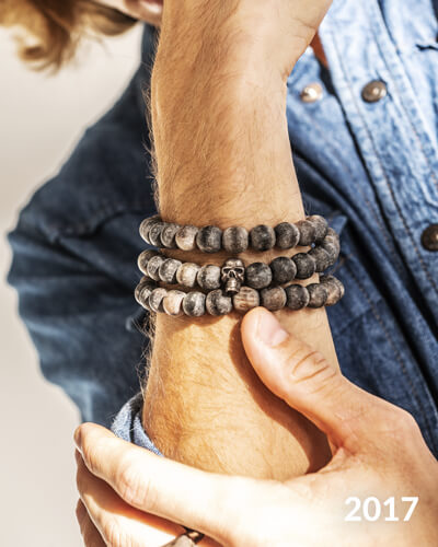 Photo d'un poignet d'homme qui porte des bijoux de créateur. 